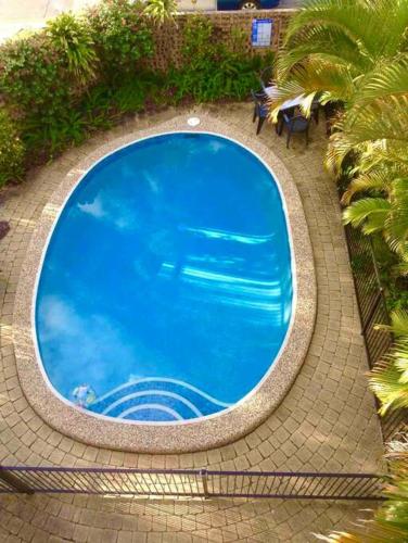 an overhead view of a large blue swimming pool at Blush on Broadbeach- beachside and pet friendly, 3rd floor walk up in Gold Coast