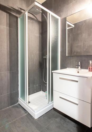 une salle de bain avec une douche avec un lavabo et un miroir dans l'établissement Reve de Jade devant le canal, à Annecy