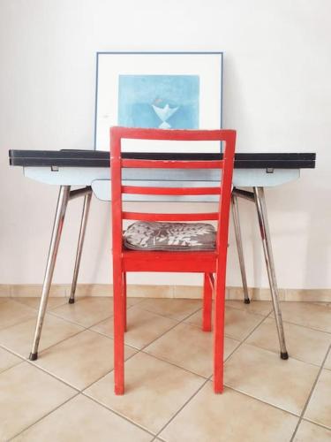 une chaise rouge assise devant le bureau dans l'établissement Studio Campanule Provence Verdon, à Riez