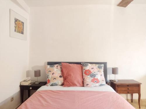 Studio Campanule Provence Verdon في ريز: غرفة نوم مع سرير وملاءات ووسائد وردية