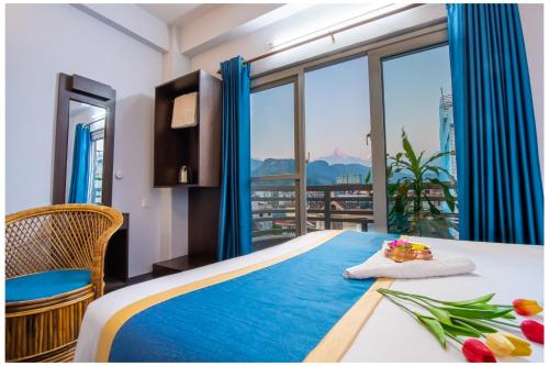 Hotel Tulip Pokhara Inn في بوخارا: غرفة نوم بسرير مطل على المدينة