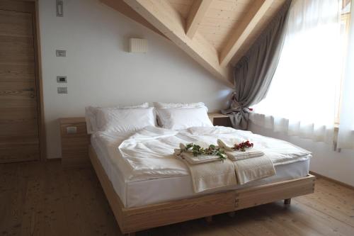 a bedroom with a white bed with flowers on it at Agriturismo Casa Preti in Revò