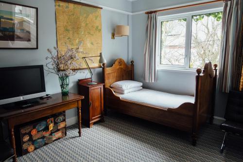 a room with two beds and a tv and a window at Cairn Bay Lodge in Bangor