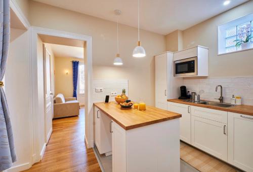 une cuisine avec des armoires blanches et un comptoir dans l'établissement La Porte Enchantée, à Chartres