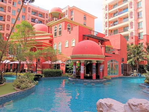 a hotel with a pool in front of a building at Seven Seas Condo Resort Jomtien Loft in Jomtien Beach