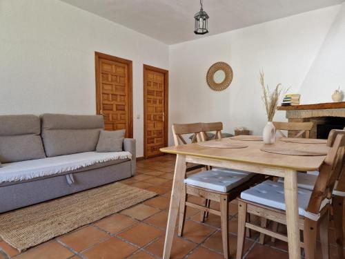 sala de estar con mesa y sofá en Las Casas de las Flores, en Los Caños de Meca