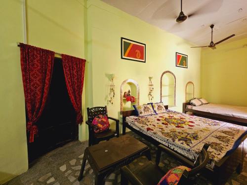 a bedroom with a bed and a table and chairs at Haveli Gulabram Ji, Bundi in Būndi