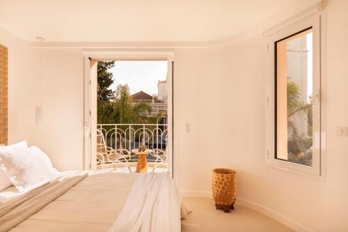 a bedroom with a bed and a large window at Maison Carla Rosa Cannes in Cannes