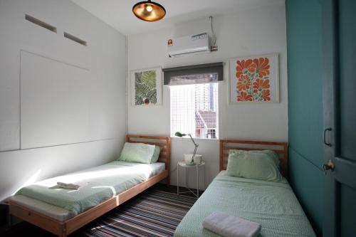 Habitación pequeña con 2 camas y ventana en Stay SongSong Mount Erskine en George Town