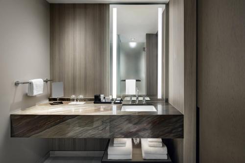 a bathroom with a sink and a large mirror at JW Marriott Edmonton ICE District in Edmonton