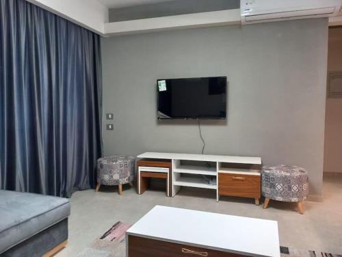 un salon avec un canapé et une télévision au mur dans l'établissement chalet 2 bedroom il Monte Galala al ain sokhna CH161-1-4, à Ain Sokhna