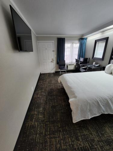 a hotel room with a white bed and a desk at Executive Lodge in Portland