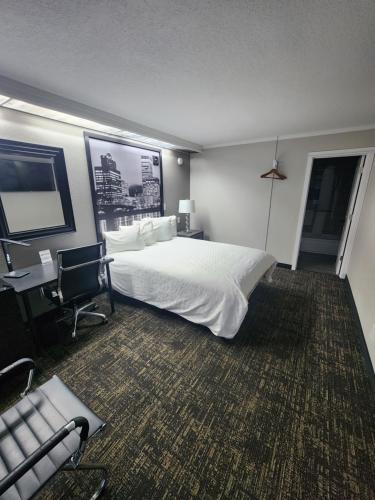 a hotel room with a bed and a desk and a chair at Executive Lodge in Portland