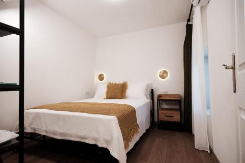 a bedroom with a white bed and a mirror at Benjamin Otel Gumusluk in Gumusluk