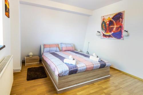 a bedroom with a bed and a painting on the wall at Central apartments - Red in Bacău