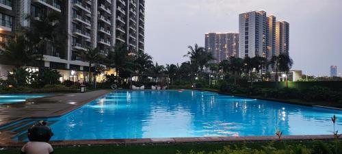 a large blue pool in a city with tall buildings at BSDE 2BR Skyhouse Jervois in Cilenggang