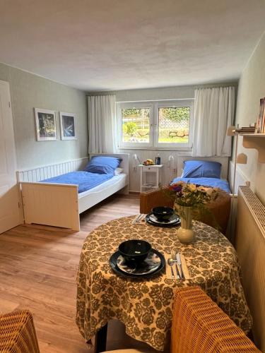 a bedroom with two beds and a table and chairs at Sonnige Souterrain-Ferienwohnung in Sassnitz