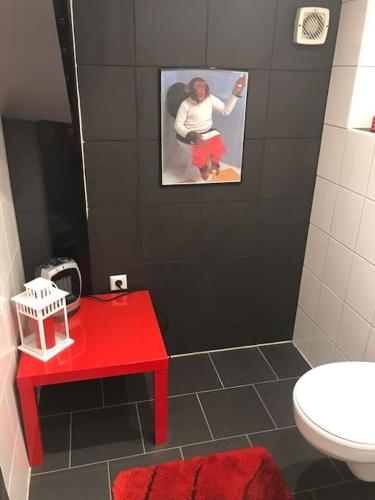 a bathroom with a red table and a red stool at Gemütliche Wohnung an der Nordseeküste 3 in Westerholt