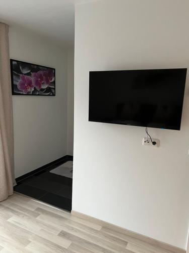 a room with a flat screen tv on a wall at Apartment 1 Gäste in Schörfling