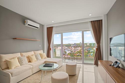 a living room with a couch and a large window at MLZ Apartments Sihanoukville in Sihanoukville