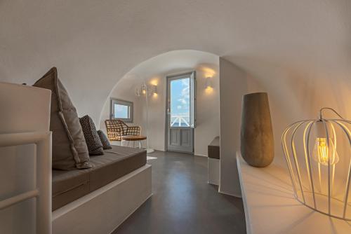 ein Wohnzimmer mit einem Sofa und einem Tisch in der Unterkunft Helianthus Suites- Caldera Caves in Oia