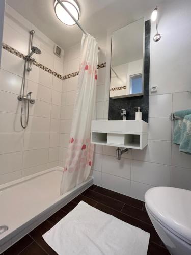 a bathroom with a tub and a sink and a toilet at Sonnige Souterrain-Ferienwohnung in Sassnitz