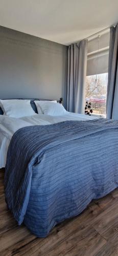 duże łóżko w sypialni z oknem w obiekcie Lägenhet Yvonne w mieście Gränna