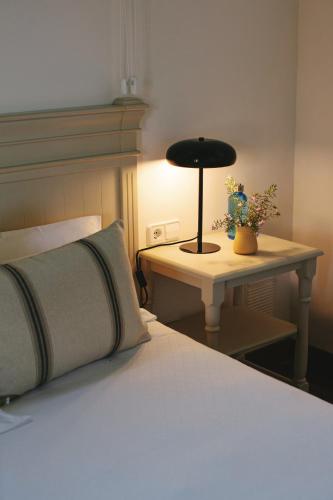 a bedroom with a bed and a table with a lamp at Can Arabí - Adults Only in Ibiza Town