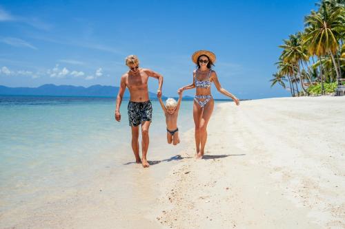 a man and a woman walking on a beach at Sea&Sky Beach Resort in Mae Nam