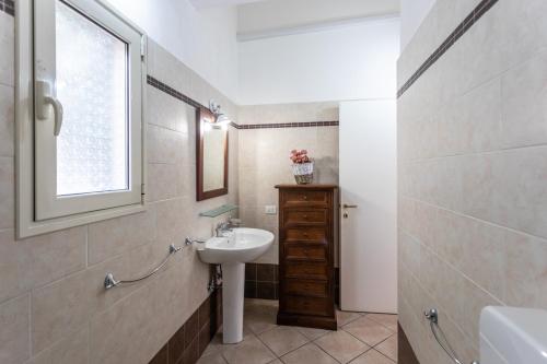 uma pequena casa de banho com um lavatório e uma janela em Villetta Bianca em Gallipoli