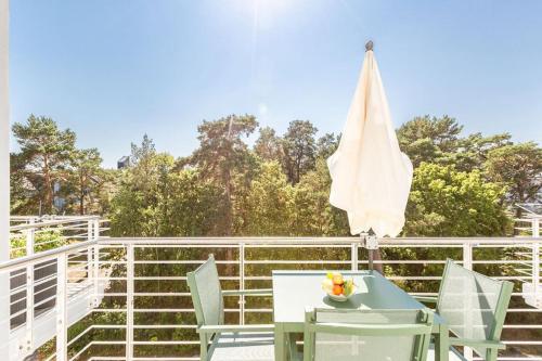 eine Terrasse mit einem Tisch, Stühlen und einem Sonnenschirm in der Unterkunft Strandresidenz Else Marie, App. 3.7 in Ahlbeck