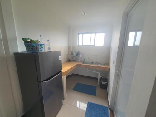 a small kitchen with a refrigerator and a counter at MB Apartments & Hotel Medan in Sunggal