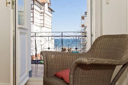 einen Korbstuhl auf einem Balkon mit Aussicht in der Unterkunft Villa Astrid, T4 Hamburg in Bansin