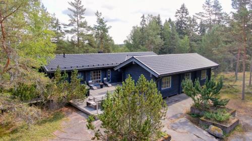 una casa azul en medio de un bosque en Villa Mustikka en Tammisaari