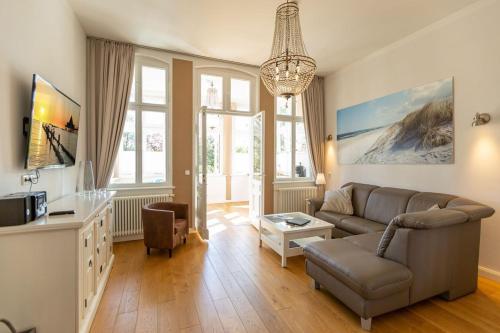 uma sala de estar com um sofá e uma mesa em Villa Saphira App 09 em Heringsdorf