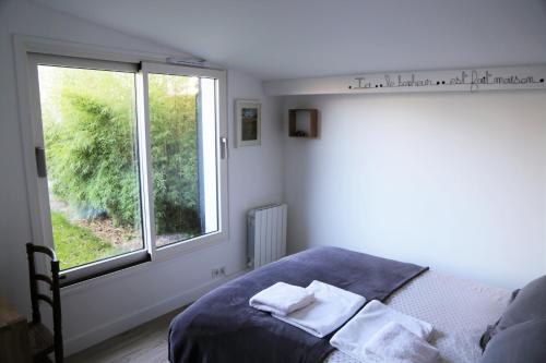 a bedroom with a bed and a window with towels on it at Chambre d'Hôtes Les Petits Oiseaux in Nantes
