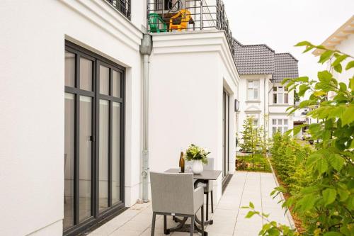 a balcony with a table and chairs on a white house at Quartier Frohsinn App 02 in Ahlbeck