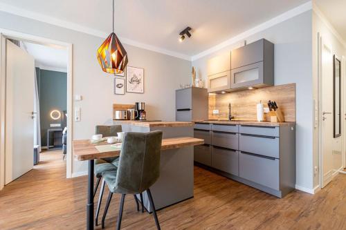 a kitchen with a table and a dining room at Quartier Frohsinn App 02 in Ahlbeck