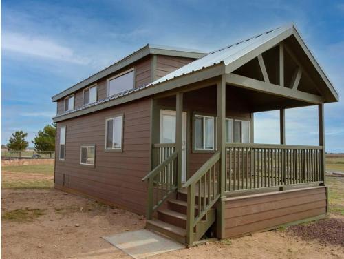 ein kleines Haus mit einer Veranda und einer Terrasse in der Unterkunft 036 Tiny Home nr Grand Canyon South Rim Sleeps 8 in Valle