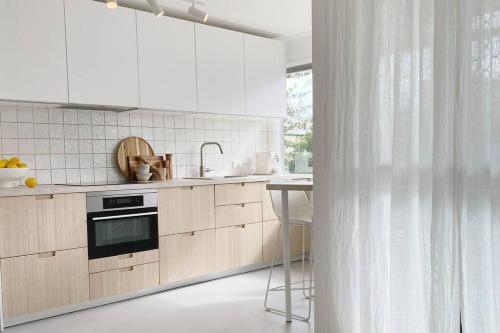 a kitchen with white cabinets and a sink and a counter at Freddies Pet-Friendly Apt Steps to Beach in Gold Coast