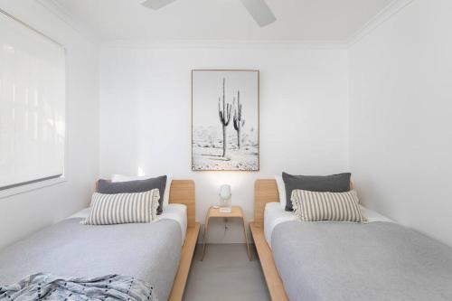 a bedroom with two beds and a side table at Freddies Pet-Friendly Apt Steps to Beach in Gold Coast