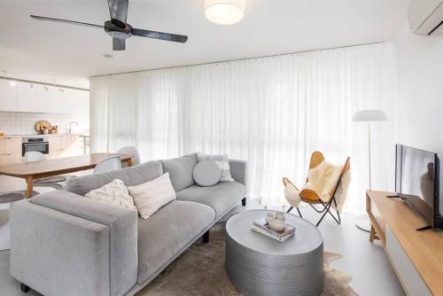 a living room with a couch and a table at Freddies Pet-Friendly Apt Steps to Beach in Gold Coast