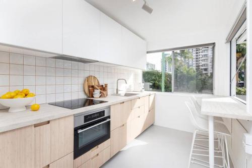 a kitchen with white walls and a large window at Freddies Pet-Friendly Apt Steps to Beach in Gold Coast
