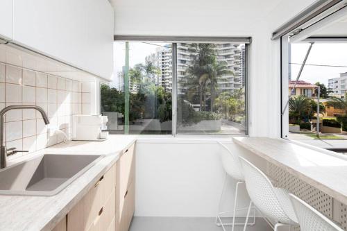 a kitchen with a sink and a large window at Freddies Pet-Friendly Apt Steps to Beach in Gold Coast
