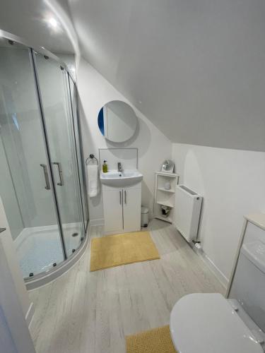 y baño con ducha, aseo y lavamanos. en Self Catering house with lovely sea views, 44 Back en Vatisker