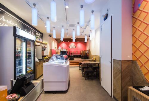 Hostel Warmoes Amsterdam في أمستردام: مطعم وجبات سريعة مع غرفة طعام مع طاولات