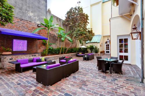 a patio with purple seats and tables and a building at Hotel Le Marais in New Orleans