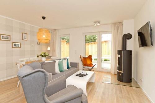ein Wohnzimmer mit einem Sofa und einem TV in der Unterkunft Villa Bettina, App. 01 in Heringsdorf