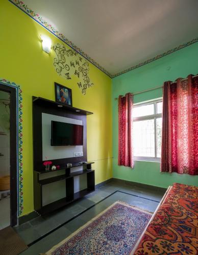 a living room with a television and green walls at Hotel Prem Villas Pushkar in Pushkar