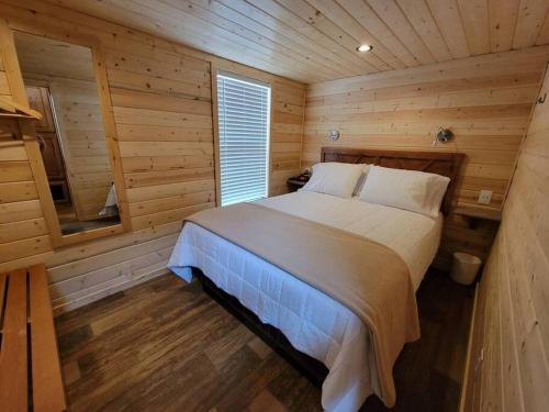 037 Tiny Home nr Grand Canyon South Rim Sleeps 8 في فالي: غرفة نوم بسرير في كابينة خشبية
